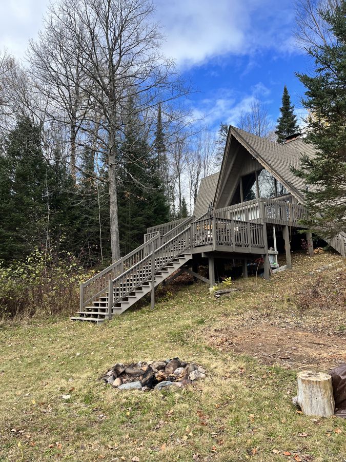 The A-frame, deck stairs, and fire pit in autumn